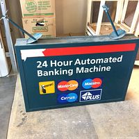 Front and top view of the rectangular bank sign with 24 hour banking text and multiple payment logos on a dark blue background with red strip above. Two metal mounting brackets at top edges.