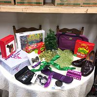 Full view of hobby collection on table with dress shoes, games, puzzle, camera filters, small tree, and novelty items