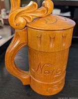 Carved wooden beer stein inscribed with 'Norway' captured to show ornate handle and exterior detail.