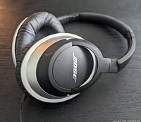 Close-up photo of Bose headphones showing over-ear design, black padded ear cups and silver accents.