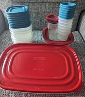 Stack of Rubbermaid plastic containers with assorted blue, red, and white lids