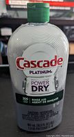 Clear plastic bottle of Cascade Platinum Power Dry rinse aid with green cap, 901 mL volume, used condition, translucent liquid visible inside