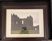 Framed photo print showing a ruined castle in Scotland with a large archway, in a dark wood frame with matting