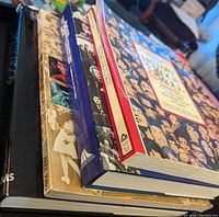 Side view of the four hardcover music and history books showing their spines and partial covers.