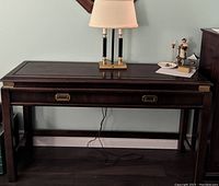 Front view of the mahogany side table with drawer, lamp on top