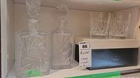 Two crystal decanters and two crystal goblets placed on a shelf, also showing Nachtmann box behind goblets.