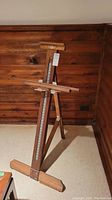 Front view of full easel in standing position showing base, uprights, and top clamp