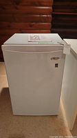 Frontal view of closed white Whirlpool mini fridge