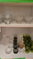 Photo showing a wider selection including green goblets, clear, smoke, and amber small drinking glasses