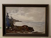 Full view of framed oil painting showing entire coastal scene and carved wooden frame.