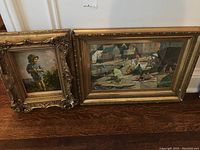 Both framed prints placed on floor showing size difference and detail of frames.