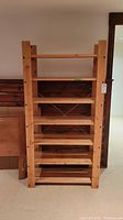 Front view of the complete wooden shelf unit showing six evenly spaced shelves and natural wood finish.