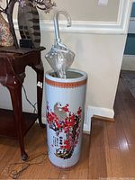 Photo of the ceramic umbrella stand showing its size and one transparent umbrella inside it.