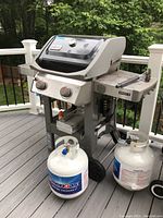 Front and side view of the grill on deck with two propane tanks visible