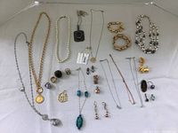 Overhead shot showing full lot of necklaces, bracelets, rings, earrings and pendants laid out on fabric