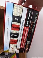Five Canadian books standing upright side-by-side showing titles and authors.