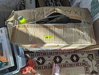 Closed, damaged cardboard box containing the pre-lit reindeer and sleigh yard decoration with visible wires and components inside.