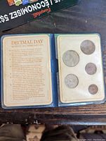 Page with informational text about UK Decimal Day 1971 and 5 commemorative coins displayed in slots.