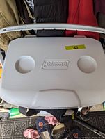 Top view of white Coleman cooler lid showing two cup holders and embossed Coleman logo