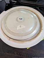 Top view of larger stoneware crock lid marked '3' with visible chips on rim.