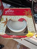 Glade wax melt warmer visible in its original packaging with red, white, and gold design.