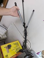 Full view of the clip-on grow light showing the three adjustable LED bars and clip base