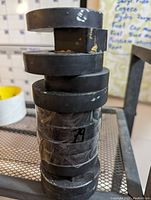 Side view of stacked heavy duty ferrite magnets, showing cylindrical and ring forms with tape securing them.