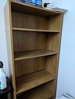 Full view of the tall bookshelf showing four shelves and wood veneer finish.