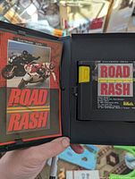Open clamshell case showing Road Rash manual and cartridge inside