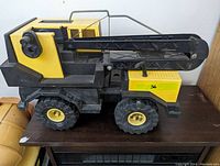 Side view of the vintage Tonka Mighty Crane truck showing the yellow and black color scheme and large tires.