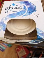 Front view of Glade ceramic wax melter in its original box, partially visible wax warmer dish.