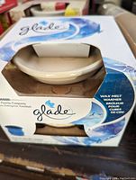 Image showing front of Glade wax melt warmer packaging and visible ceramic dish warmer inside box.