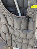 Front view of the black padded weighted vest showing the multiple compartments for weights.