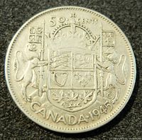 Close-up of the reverse side of the 1945 Canadian 50 cents silver coin showing coat of arms and denomination.