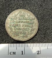 Close-up of coin side with German inscription mentioning Carl Theodor and the date 31 Dec 1792, placed on dark surface with measuring scale showing about 2 cm diameter.