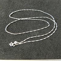 Sterling silver chain necklace laid out on black background showing chain length and clasp details.