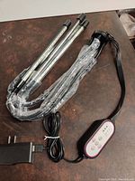 New, unused full spectrum LED grow lamp with four individual LED light bars connected by flexible cables, black control unit with timer and spectrum adjustment buttons, and power adapter included.