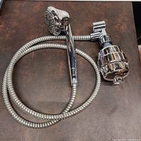View showing entire massage shower head with attached flexible hose and integrated water filter attached inline.