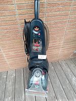 Black Bissell ProHeat 2X carpet cleaner upright model with water tanks, control dial, power button, and wrapped power cord, untested condition.
