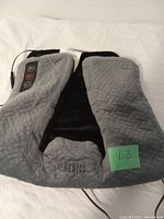 Front view of the HoMedics heated massage wrap showing grey basket-weave textured fabric and control panel with 3 buttons.