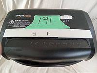 Close-up of the shredder top control area with AmazonBasics branding and control switch visible.