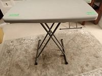 Full view of folding TV table with metal legs on carpet