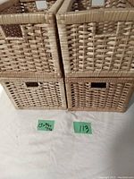 Four light brown woven wicker baskets stacked with green size labels