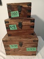 Three vintage wooden boxes stacked, showing front and top view with latch and metal hardware.