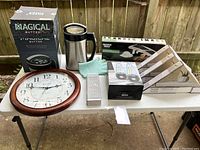 Photo showing the entire lot of household items including Magical Butter Extractor box, large clock, shelves, candle holders, oven mitts, grater, and soap dispenser.