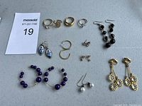 Photo of assorted jewelry including rings and multiple styles of earrings laid out together