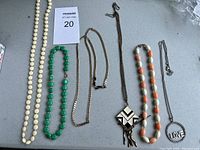 Full view of six necklaces on table, showing all items in the lot