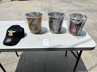 Overview of black Grogu hat and three Star Wars collectible bins wrapped in plastic on white table.