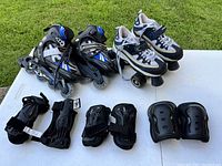 Full set of youth skating equipment including inline skates, quad skates, and protective pads laid out on a table outdoors.
