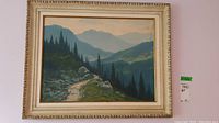 Frontal image of the original oil on board mountain landscape painting in vintage carved wood frame with cream finish.